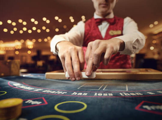 The croupier holds poker cards in his hands at a table in a casino.